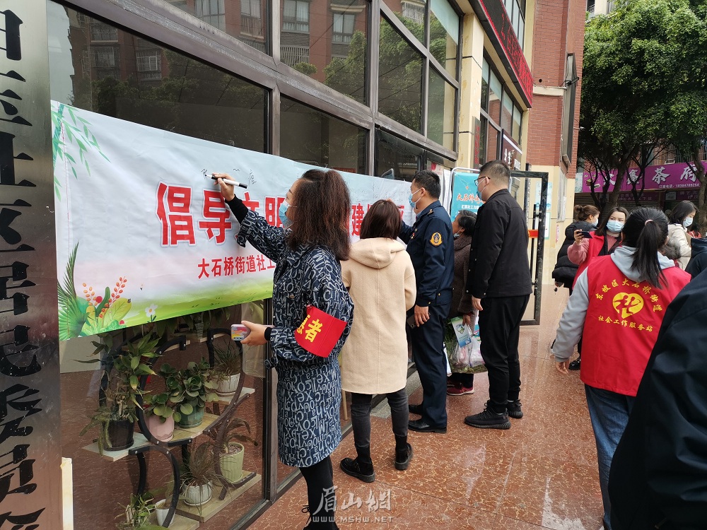 在文明新風(fēng)倡導(dǎo)簽名墻前，轄區(qū)居民和志愿者們鄭重簽名。.jpg
