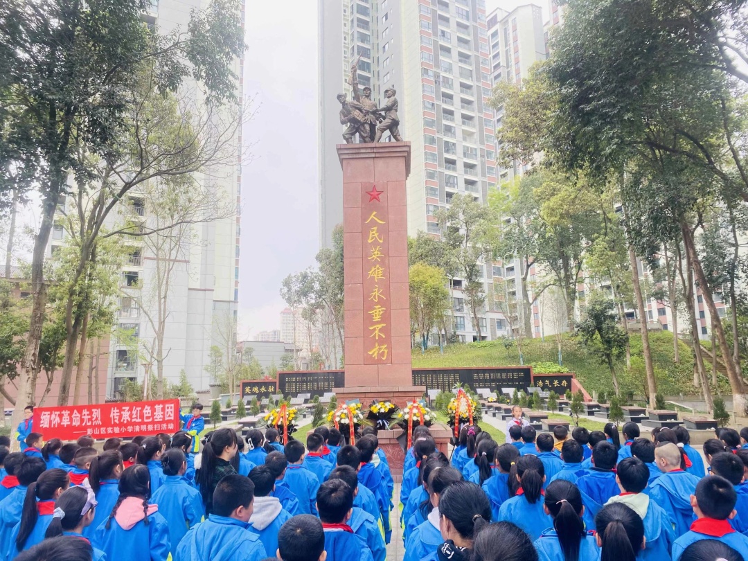 師生們?cè)谂砩絽^(qū)烈士陵園紀(jì)念碑前默哀。.jpg