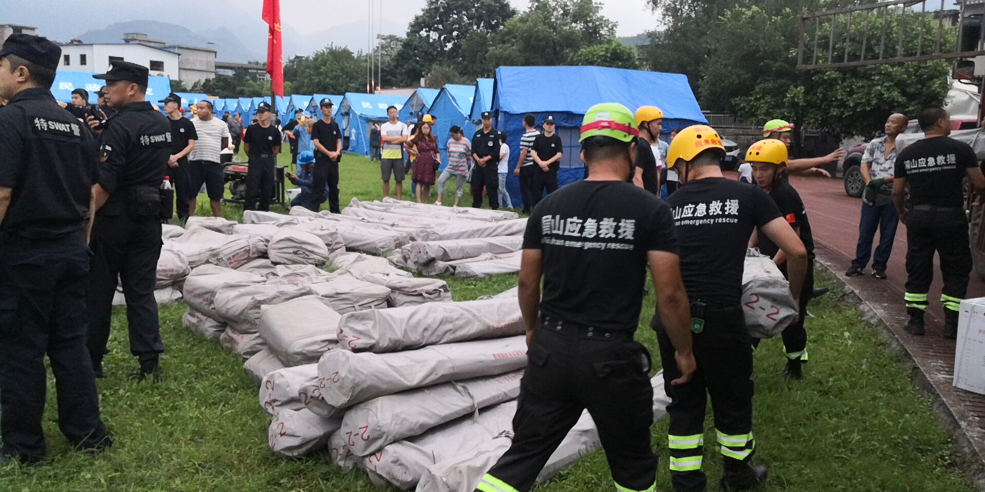 18日晚7時(shí)20分左右，救援隊(duì)員和武警官兵冒雨為群眾搬運(yùn)救災(zāi)帳篷。2.jpg