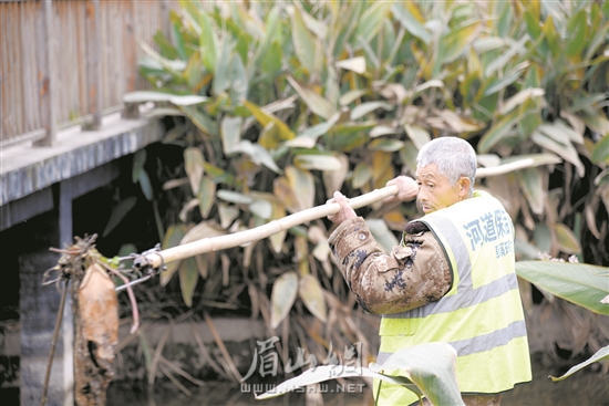 徐雙貴正在打撈河道雜物。.jpg