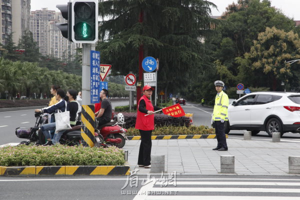交警、交通志愿者共同維護(hù)交通秩序。
