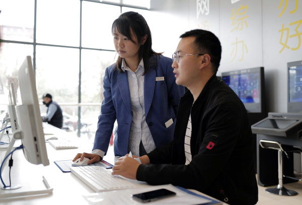 行政審批部門的工作人員現(xiàn)場指導(dǎo)辦事群眾。