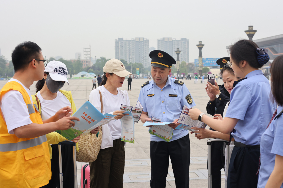工作人員在眉山東站外向旅客宣傳愛護(hù)鐵路相關(guān)知識(shí).JPG