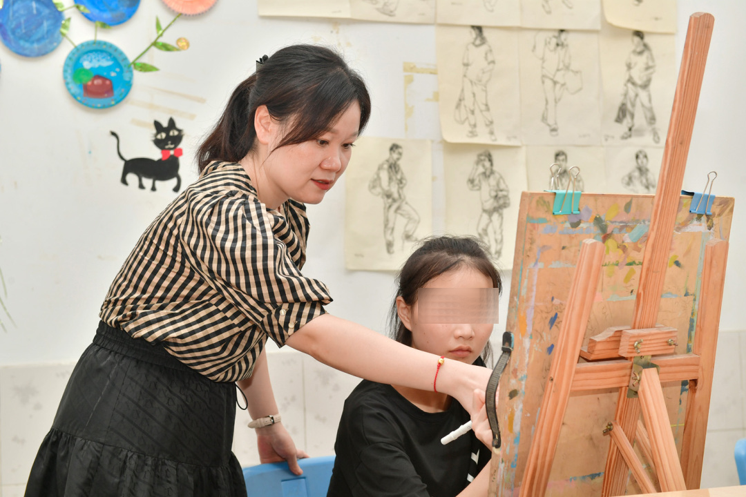 曾真老師正在指導學生畫畫。.jpg