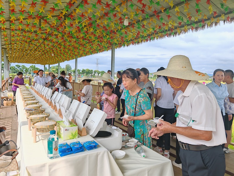  活動現場大米品鑒區(qū)，村民正在品嘗新品種大米。