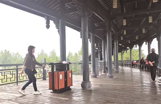 東坡城市濕地公園的望月臺(tái)空中廊橋上，市民將垃圾扔進(jìn)垃圾箱。.jpg